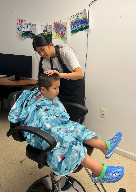 Ava giving a young boy a haircut