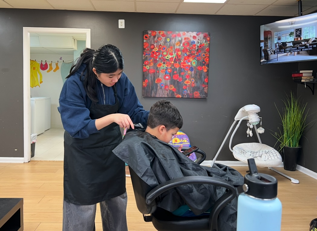 Ava cutting a young boy's hair