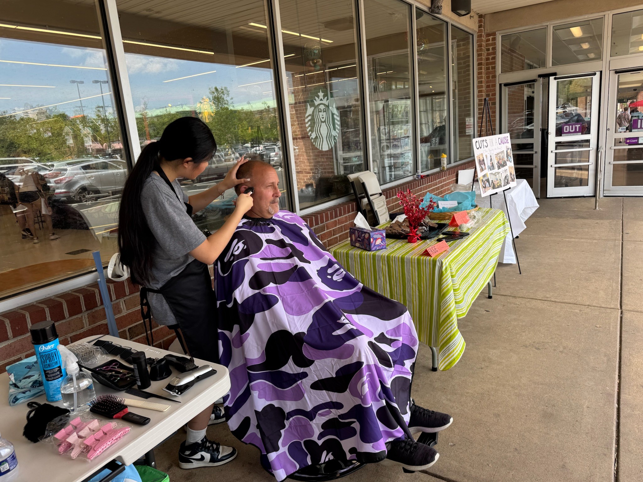 Ava providing a haircut during a community fundraiser